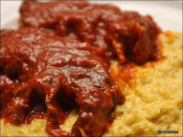 Detalle de AAsado de Tira con Pastelera, carne de larga cocción con salsa de tomates acompañado por cremosa pastelera