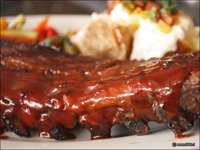 Primer plano de costillas de cerdo con salsa BBQ de Tony Romas - Tony Romas (Parque Arauco)