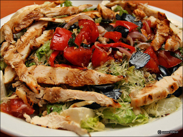 Bruschetta Chicken Salad, tiras de pollo grillado, aceitunas y gajos de tomate sobre mix de lechugas