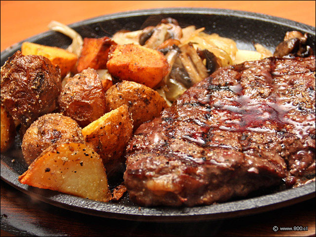 Bourbon Steak, lomo liso al grill con cebolla frita, championes salteados y papas asadas