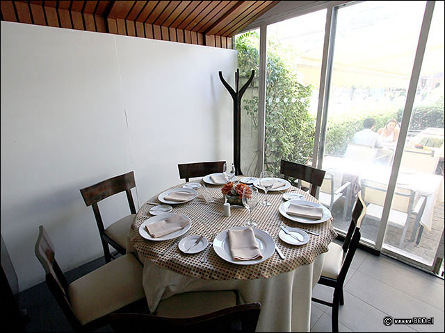 Mesa a un costado de la barra y salida a la terraza - Casa Santa Brasa Vitacura