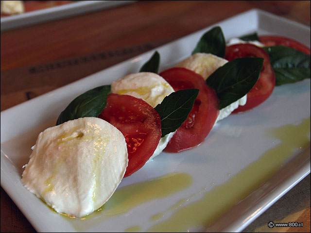 Antipsti Caprese con Mozzarella di Bufala DOP, Tomate y hojas de albahaca - Trattoria Rita - Parque Arauco