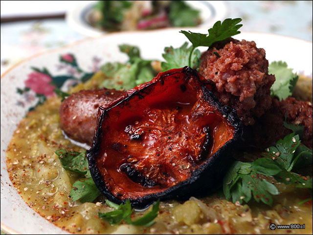 Tomate asado y longaniza montados sobre el guiso de arvejas - Salvador Cocina y Caf