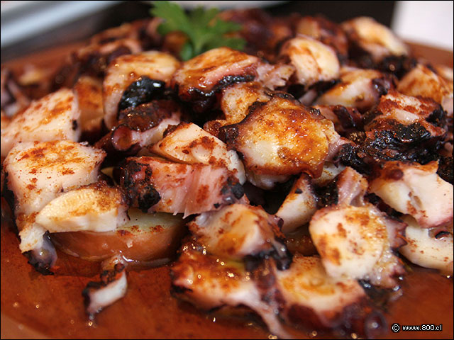 Dados d pulpo cocido servido sobre papas y espolvoreado con paprika - Formentera