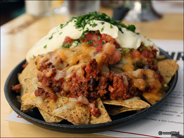 Los golosos Nachos cubiertos de chilli, pico de gallo, salsa cheddar y crema ácida - La Burguesía - Providencia
