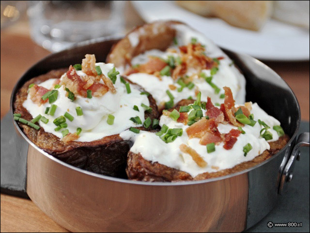 Papas al horno con crema cida y tocino crocante - Infiltrados Steak Bar