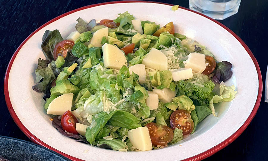 Una ensalada lechuga, palta palmito tomate, para acompañar el filete