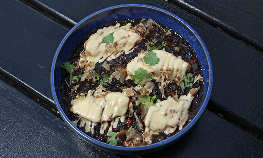 Arroz negro en caldo de mariscos con pescado frito y katsuobushi