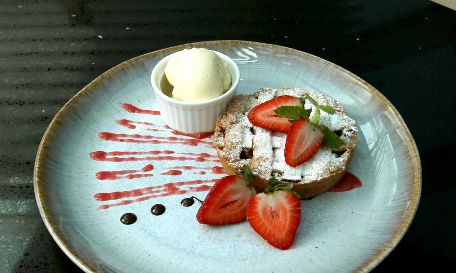 Tarta de manzana con helado y frutillas