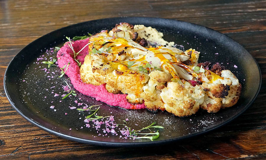 Coliflor grillada y laminada sobre hummus