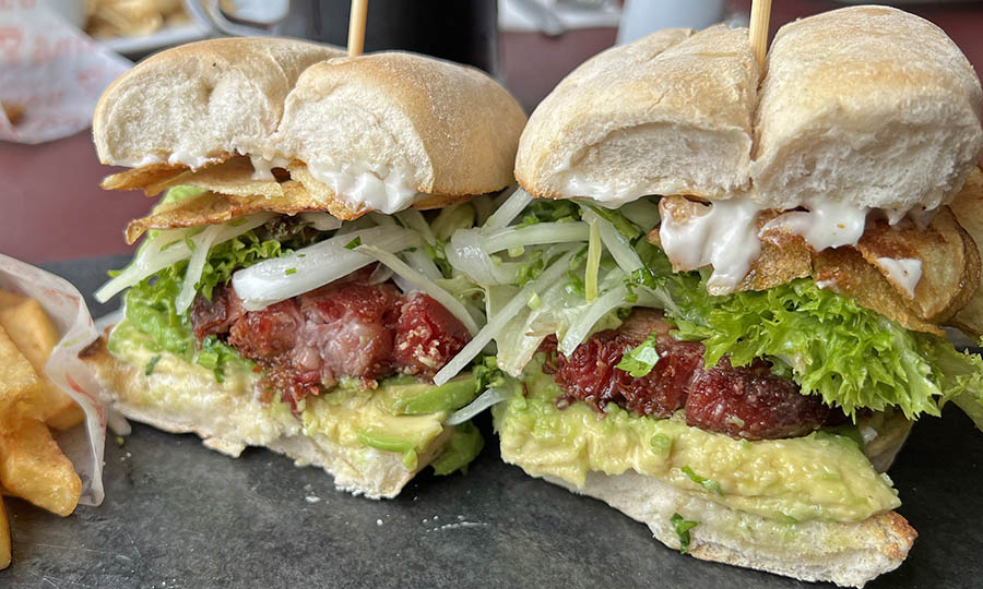 Sandwich de pernil frito con cebolla, lechuga, papas chip y mayo - Bierstube - Club Manquehue