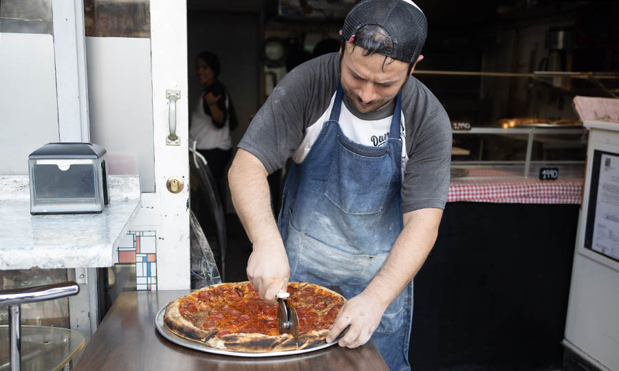 El maestro Danny en el corte - Dannys New York Style Pizza