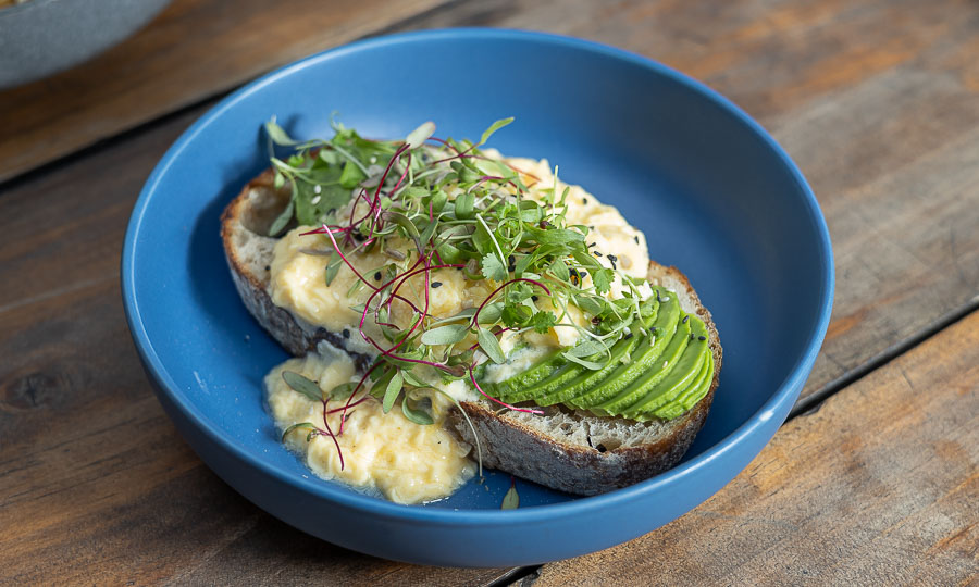 Gruesa tostada de palta con sanos huevos revueltos