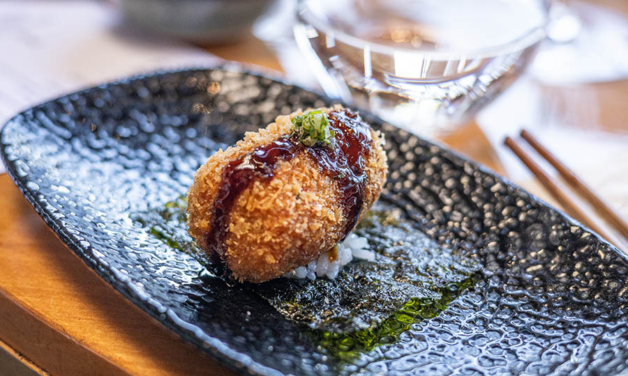 Sabrosa Croqueta de centolla sobre arroz y nori con salsa unagi 