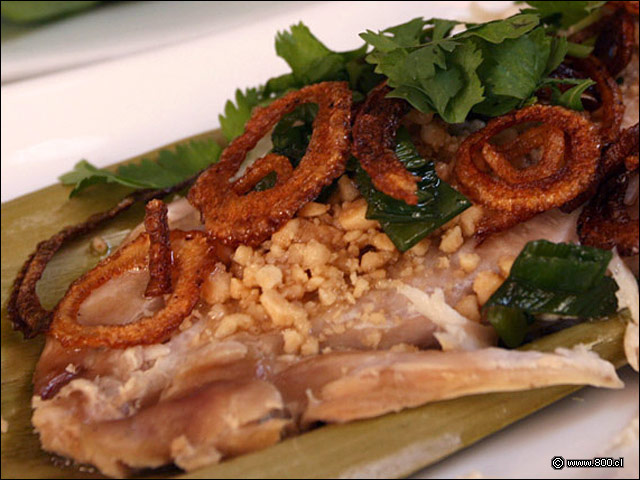 Detalle de filete de pescado, aros de cebolla y man molido en Pescado al Horno