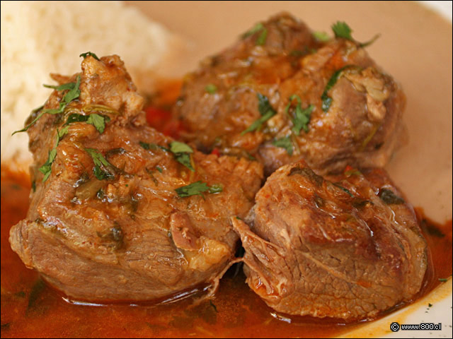 Detalle de Cabrito Norteo, cabrito asado lentamente acompaado de salsa de porotos negros y arroz blanco - El Aj Seco del Inca - Ex El Chaln