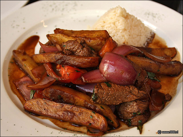 Lomo Saltado, dados de filete, gajos de tomate y cebolla morada salteados con soya junto a papas fritas acompaado por arroz blanco - El Aj Seco del Inca - Ex El Chaln