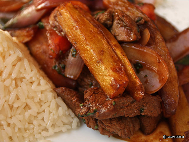 Detalle de Lomo Saltado, dados de filete, gajos de tomate y cebolla morada salteados con soya junto a papas fritas acompaado por arroz blanco - El Aj Seco del Inca - Ex El Chaln